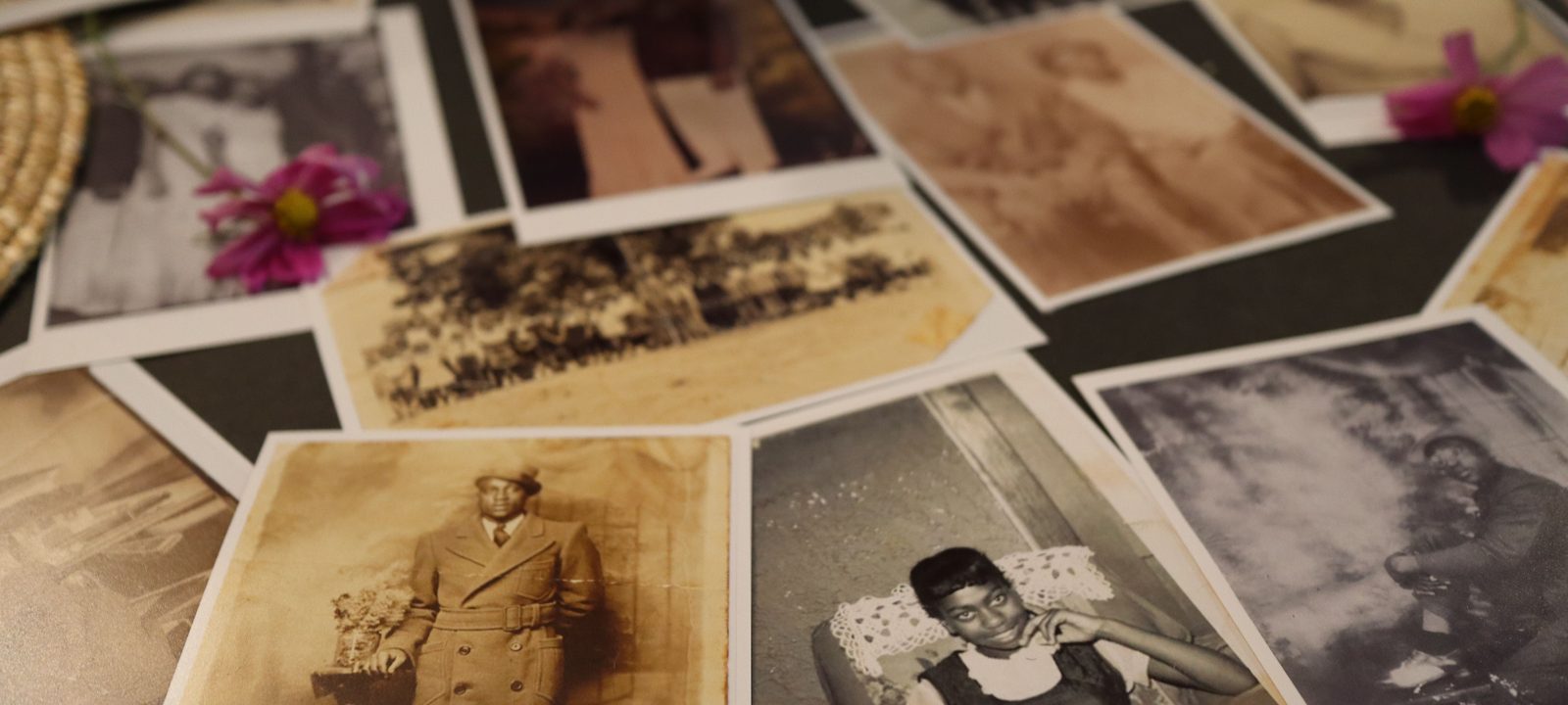 A collection of vintage sepia photographs scattered on a table, evoking nostalgia.
